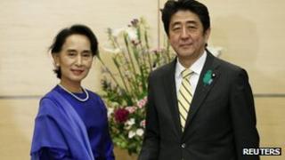 Nobel laureate and Burma opposition leader Aung San Suu Kyi (L) shakes hands with Japan's Prime Minister Shinzo Abe at Abe's official residence in Tokyo 18 April 2013.