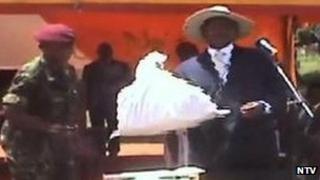 President Yoweri Museveni holding a bag of money