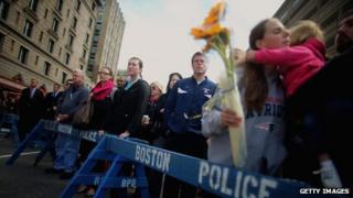 People gather during a moment of silence honouring the Boston Marathon bombing victims in Copley Square, near the bombing sites in Boston, Massachusetts, 22 April 2013
