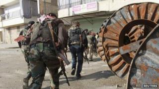 Free Syrian Army fighters carry their weapons as they move towards their positions during an infiltration operation in Aleppo's neighbourhood of Salaheddine
