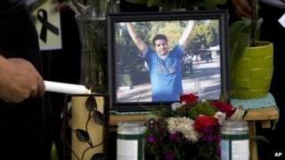 A mourner lights candles at a makeshift memorial for Ricardo Portillo