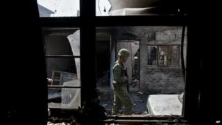 A soldier examines houses in Ecatepec after a gas tanker exploded on 7 May 2013