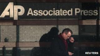 Человек смотрит на свой телефон возле офиса Associated Press на Манхэттене, Нью-Йорк (13 мая 2013 года)
