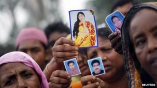 Родственники показывают фотографии пропавших без вести работников швейной промышленности во время акции протеста с требованием смертной казни для лиц, ответственных за обрушение здания Rana Plaza в Саваре, недалеко от Дакки, 29 апреля 2013 года.