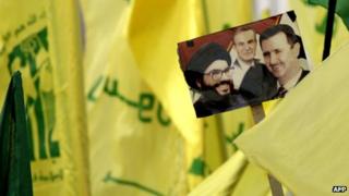 Hezbollah supporters (not seen) hold a picture of Hezbollah leader Hassan Nasrallah (L), Syrian President Bashar al-Assad (R) and his late father president Hafez al-Assad (C) in the southern town of Bint Jbeil on 22 September 2012