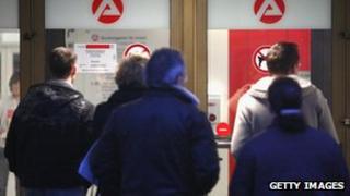 People wait in front of the unemployment agency in Wuppertal, Germany