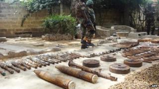 Soldiers stand around a cache of weapons display on 30 May 2013 in the Bompai area of the northern Nigerian city of Kano
