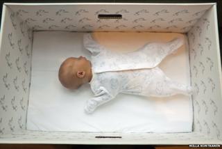 Ребенок спит в одной из родильных коробок