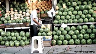 Street vendor selling watermelon in his shop in Sarcheshmeh street in downtown Tehran on June 4, 2013