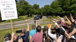 Protesters shout and wave a placard at the annual Bilderberg meeting in Watford, UK.