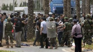 Lebanese soldiers and Hezbollah supporters are seen gathered in front of the Iranian embassy in Beirut