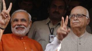 In this Dec. 17, 2012 file photo, Gujarat Chief Minister Narendra Modi, left, flashes a victory sign as he sees off Bharatiya Janata Party (BJP) senior leader Lal Krishna Advani, right