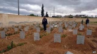 A handout picture released by Syria"s opposition-run Shaam News Network shows people gathering in a cemetery following a funeral in the central city of Homs