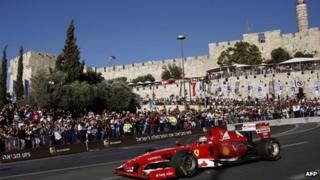 Three-time F1 Grand Prix winner Giancarlo Fisichella drives his Ferrari Formula 1 car below the ancient walls of Jerusalem's Old City on June 13, 2013 during the first Jerusalem F1 Peace Roadshow.