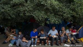 Люди обедают под елкой на площади Таксим