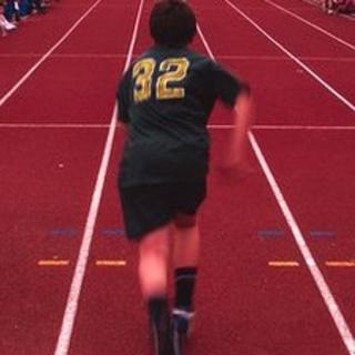 A boy running a race at school sports day