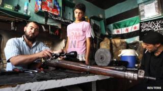 Abu Mohammad, a gunsmith, repairs a gun in his shop in the city of Aleppo