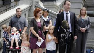 Family attorney Michael Silverman, right, holds hands with Coy Mathis as he speaks at a news conference at the Capitol in Denver on 24 June 2013