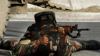 An Indian Army soldier takes position at the site of shootout on the outskirts of Srinagar, India, Monday, June 24, 2013