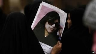 A Bahraini anti-government protester carries a picture of jailed opposition activist Zainab al-Khawaja