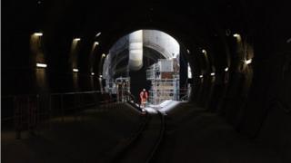 Строитель стоит в туннеле Crossrail