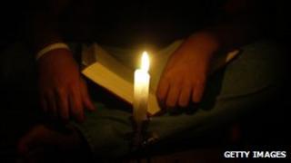 Man reads the Bible by candlelight in Syria monastery