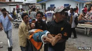 An injured resident is evacuated to the local clinic after a strong earthquake hit in Bener Meriah district in Central Aceh, Indonesia, 2 July 2013.