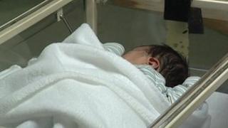 Baby in hospital cot