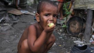 An Indian child eats rice in a slum in Guwahati in Assam on 4 July 2013