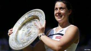 Marion Bartoli lifts Wimbledon trophy.
