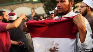 A man holds up a bloodied shirt at a pro-Morsi rally in Cairo. Photo: 8 July 2013