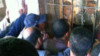 Relatives of those killed in Monday's clashes in Cairo plead with mortuary officials for their bodies to be released (9 July 2013)