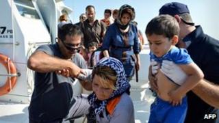 Coastguards help migrants disembark off boat in Ierapetra, Crete, on 9 July 2013