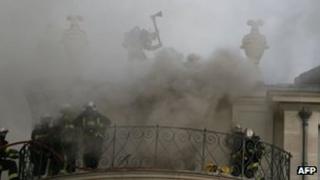Firefighters on roof of burning mansion