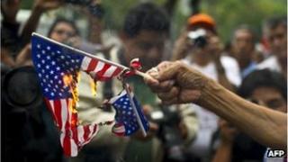 Женщина сожгла флаги США во время акции протеста в поддержку президента Боливии Эво Моралеса перед посольством США в Мехико 4 июля