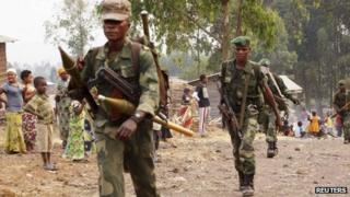 Congolese government army soldiers walk towards the frontline where they are fighting against M23 rebels outside the eastern Congolese city of Goma, 14 July 2013