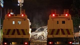 Police vans near burnt out car on Shore Road in north Belfast