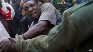 A man accused by the Congolese army of being a spy of rebels of the M23 movement is tied and taken away on 16 July 2013 in Munigi on the outskirts of Goma in the east of the Democratic Republic of the Congo