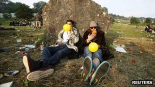 Revellers at Glastonbury inhaling laughing gas from balloons