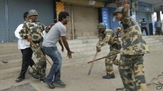 security officers use batons to charge at a man protesting against Telangana state on Wednesday, July 31, 2013