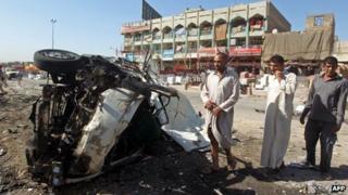 A picture taken on July 29, 2013 shows Iraqis inspecting the site of a car bomb explosion in the impoverished district of Sadr City in Baghdad.