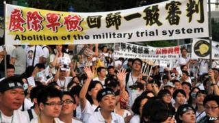 Protesters hold placards during an anti-military rally in front of Taiwan's presidential office in Taipei on 3 August 2013
