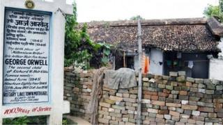 In this photograph taken on December 30, 2009, a signpost announces the birthplace of British author George Orwell in front of a dilapidated residence in Motihari