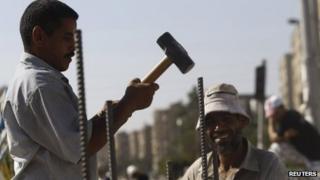 A supporter of deposed Egyptian President Mohamed Morsi builds a wall at the entrance to the Rabaa al-Adawiya protest camp