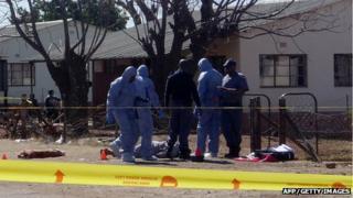 Police officers near body of dead union official at Marikana (12 August 2013)