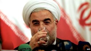 Избранный президент Ирана Хасан Рухани выпивает стакан воды во время пресс-конференции в Тегеране 17 июня 2013 года.