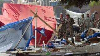 Egyptian soldiers walk amid the remains of the destroyed camp of ousted Mohammed Morsi supporters outside Rabaa al-Adawiya mosque on August 15, 2013 in Cairo, Egypt.