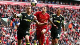 Liverpool's Daniel Agger (C) is challenged by Stoke City's Ryan Shawcross (L) and Geoff Cameron during their English Premier League soccer match at Anfield in Liverpool, on 17 August