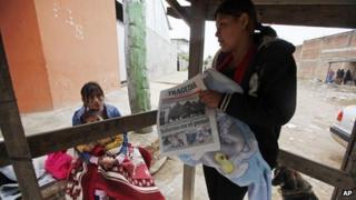 A woman reads a newspaper in front of Palmasola jail on Santa Cruz, Bolivia, on 24 August 2013