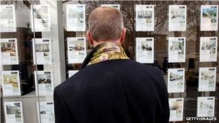 Man looking in estate agent's window